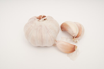 Still life photograph of fresh garlic bulb and cloves on white background for culinary blogs recipe cards and healthy cooking promotions minimalist style