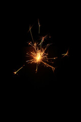 Yellow sparks fly on a black background, layered with grain, noise, and glowing effects to give a...