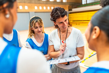Female basketball coach explaining game strategy to team