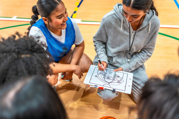Female basketball coach explains game strategy to team