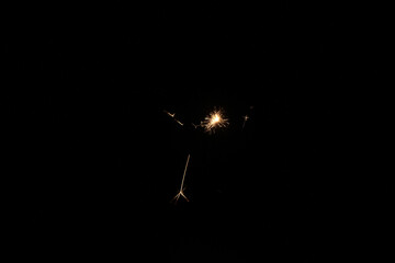 Yellow sparks fly on a black background, layered with grain, noise, and glowing effects to give a...