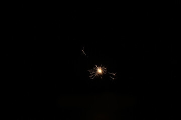 Yellow sparks fly on a black background, layered with grain, noise, and glowing effects to give a...