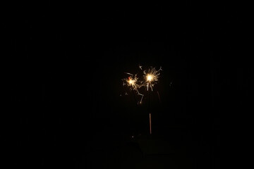 Yellow sparks fly on a black background, layered with grain, noise, and glowing effects to give a...