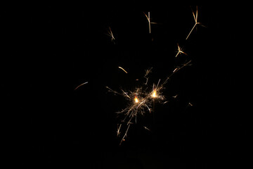 Yellow sparks fly on a black background, layered with grain, noise, and glowing effects to give a...
