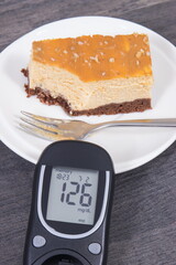 Glucometer using for sugar level control and portion of sweet cheesecake. Nutrition during diabetes