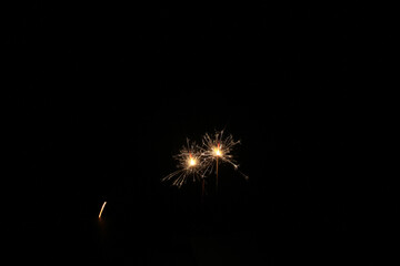 Yellow sparks fly on a black background, layered with grain, noise, and glowing effects to give a...
