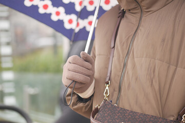Person holding umbrella during rainy day in city