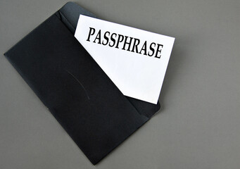 PASSPHRASE - word on white paper on a black envelope with a magnifying glass