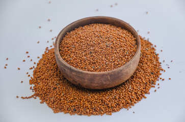 Camelina sativa seeds, camelina seeds in wooden bowl isolated on white background. Raw material for camelina oil.