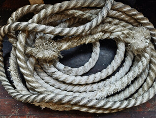 A sailor ropes is laying spread out on a wooden floor