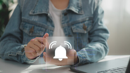Digital notification alert icon on virtual screen with hand interaction. Concept of mobile app alert, system reminder, real-time update, user interface design, and communication tech.