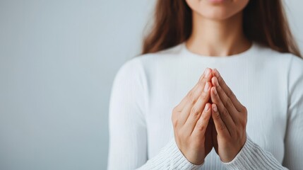 Calm Woman with Folded Hands in White Sweater, Signifying Peace and Serenity in Neutral Background
