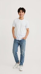 Full length of confident Taiwanese boy smiling in a casual outfit in a white tshirt and jeans standing with his arm and leg crossed on plain white background
