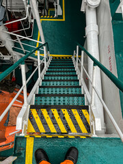 The ladder between external decks on board of the ship. The ladder has safety marking and anti-slip coating to prevent seafarers from slipping and falling, Hand rails is mandatory element for safety © Vitaliy