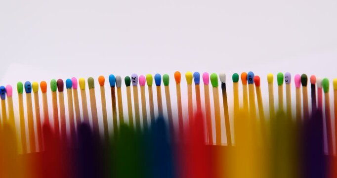multicolored match sticks in rotation on a rotating table with white background, close up view, full screen