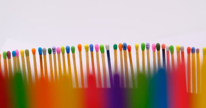 multicolored match sticks in rotation on a rotating table with white background, close up view, full screen