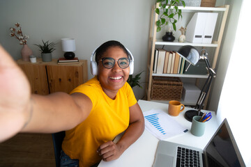 Cheerful young manager taking selfie at home office desk
