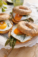 Bagels with a fried egg and green asparagus, close-up view. Healthy vegetarian breakfast