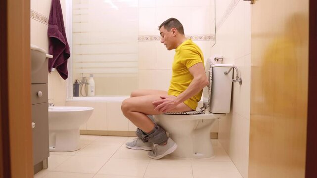 Man struggling with great constipation on toilet