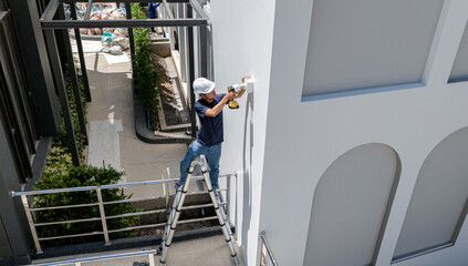 A technician installs a CCTV camera on the facade of a residential building