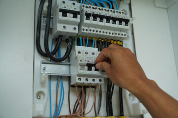 Electrician working checking a switchboard with fuses