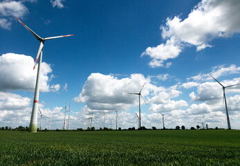 Modern wind turbines spinning over vibrant green fields in rural Germany. A powerful symbol of the Energiewende and Germany’s response to climate change and energy transition. green energy