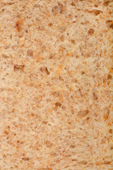 Close-up of the texture of a slice of whole wheat bread, showing visible grains and pores