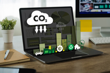 Business sustainability image shows laptop desk displaying environmental and sustainability icons...