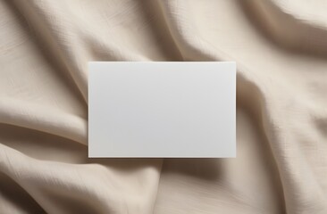 Fototapeta premium Minimalist stationery mockup: Blank white card on soft beige fabric background