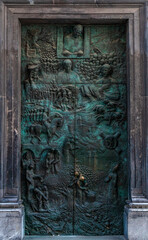 Detailed bronze door of St. Nicholas Cathedral in Ljubljana, Slovenia, featuring intricate relief...