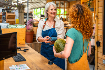 Woman paying with contactless payment in grocery store