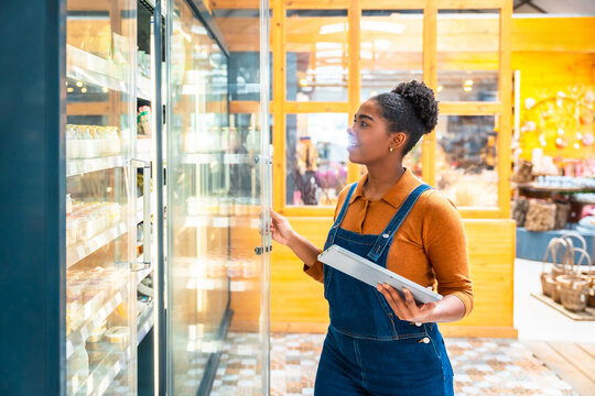 Supermarket employee checking food products using digital tablet - Powered by Adobe