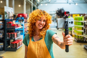 Supermarket employee vlogging using smartphone and microphone promoting products