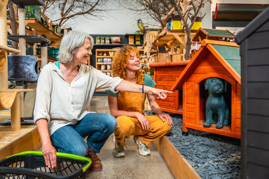 Shop assistant showing dog kennel to a customer in a pet shop