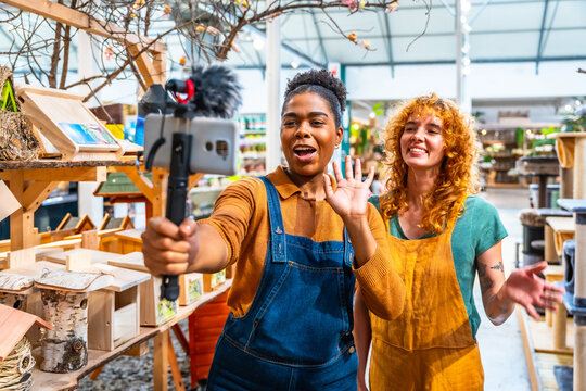Two saleswomen filming a video for social media marketing in a pet shop