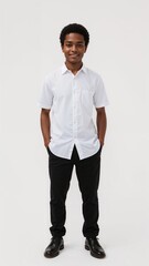Full length of confident Ghanaian boy in a white shirt and black trousers standing with hands in back pockets and smiling on plain white background
