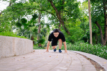 Runner preparing to start a sprint in a lush green park during a sunny day