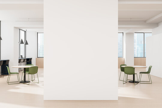 Empty white wall mockup in modern office interior with round tables and green chairs, ideal for branding, poster or canvas design display concept. 3D Rendering