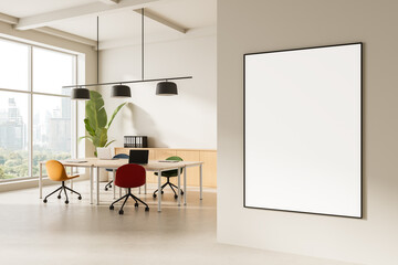 Modern office interior with blank poster frame on wall near meeting table and colorful chairs in bright workspace with city view window. 3D Rendering
