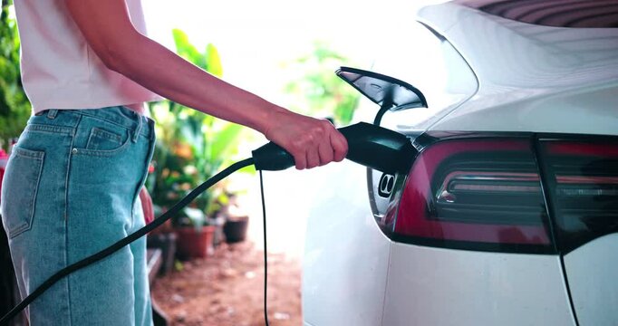 Woman hand use EV car charge home station transport technology