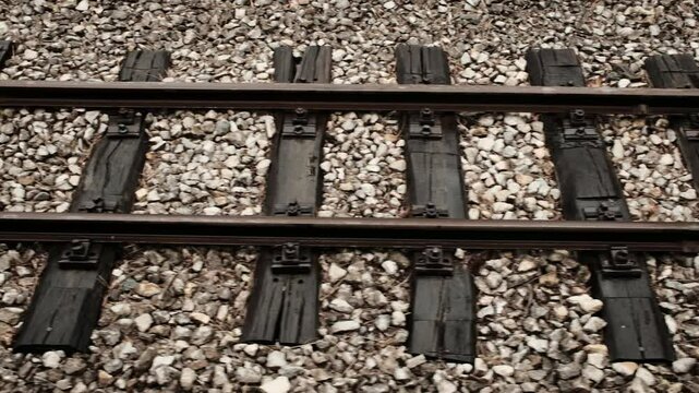 Close-up of old rusty railroad tracks and wooden ties on gravel in Mokra Gora, Serbia. Horizontal 4k footage