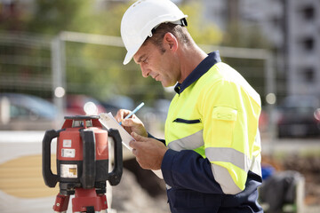 mature geometer working on construction site