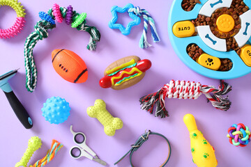 Flat lay of various pet supplies, including an interactive feeder, rope toys, a collar, and...