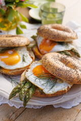 Bagels with a fried egg and green asparagus, close-up view. Healthy vegetarian breakfast
