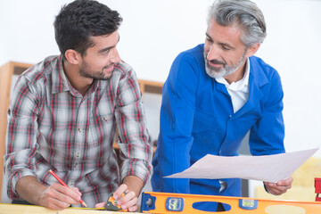 workers using spirit level against workshop