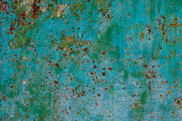Rusty green metal surface with peeling paint in industrial area
