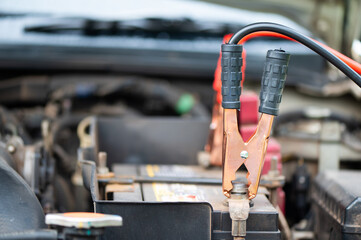 Close-up at a service station. Car battery with pliers to charge the battery.
