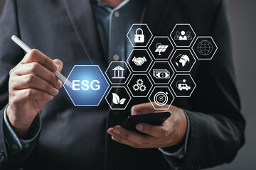 A businessman analyzes ESG data with a smartphone, showcasing digital icons representing...