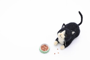 ペットフードの前に寝転ぶ猫の羊毛フェルト