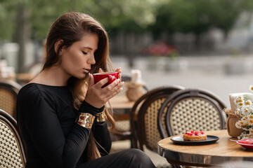 Woman Coffee Cafe: Stylish girl drinking coffee at outdoor cafe in daytime for relaxation.